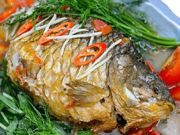 cá chép giòn om dưa đầy đặn với màu vàng của nghệ, màu đỏ của cà chua và xanh của hành lá thì là